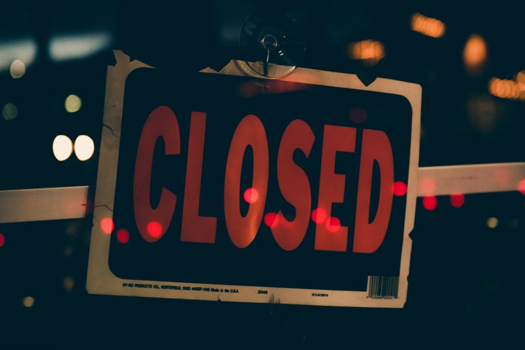 a closed sign to reflect an institution that is no longer existing
