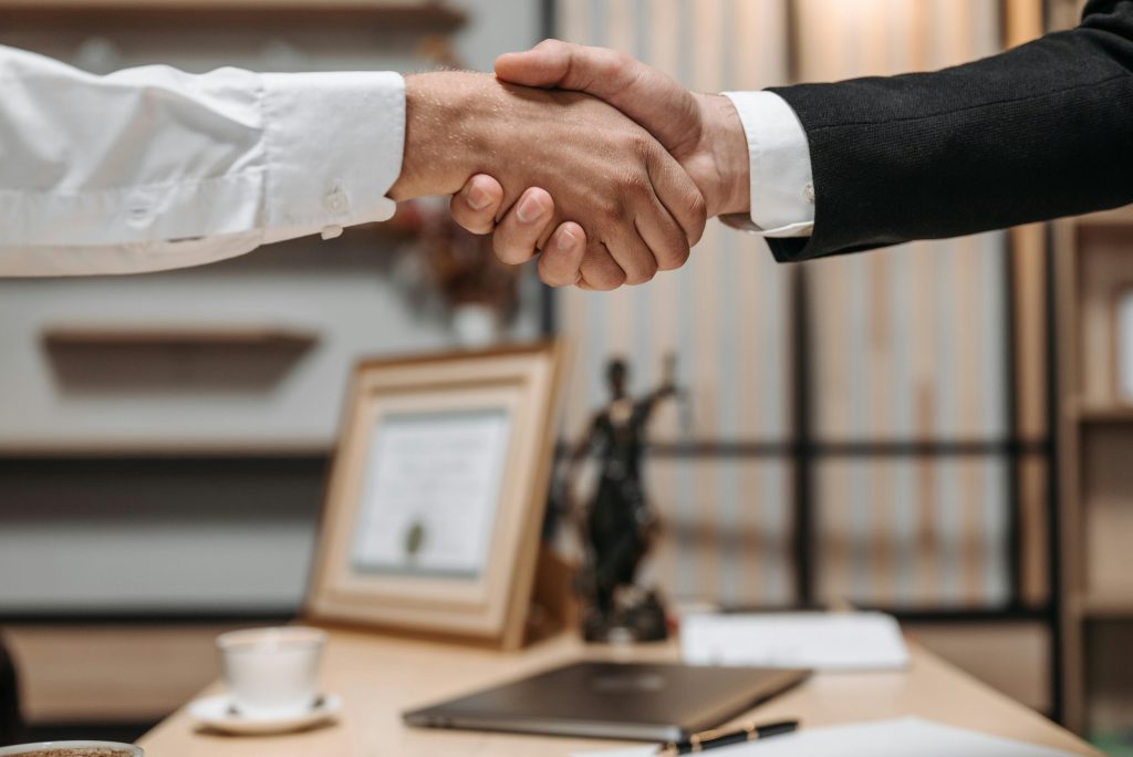 a shakehand between a lawyer and a client to discuss a case